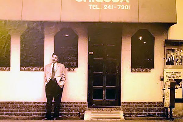 昔のお店の前でポーズをとる日野皓正さん